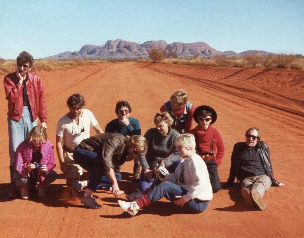 Handspan On the Road people sitting on a red desert road