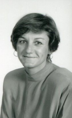 black and white portrait of woman grinning at camera