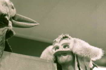 performer in bunyip mask conversing with puppet kookaburra