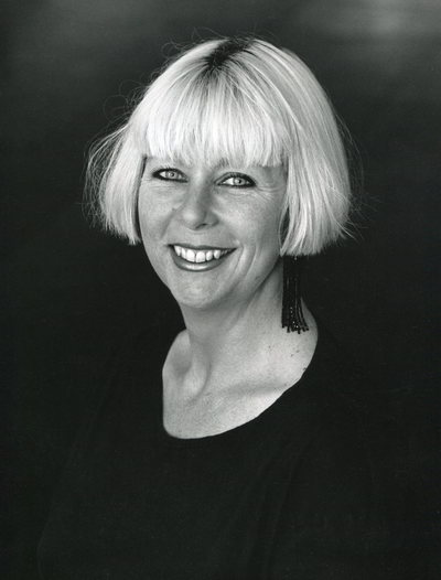 Handspan Theatre Annie Wylie black and white portrait of smiling woman with bobbed fair hair and long earrings