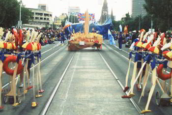 two troops of mechanical puppet figures dressed as lifesavers marching along wide city boulevarde